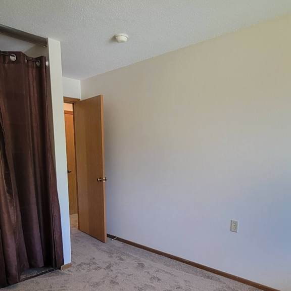 a room with a brown door and carpet.
