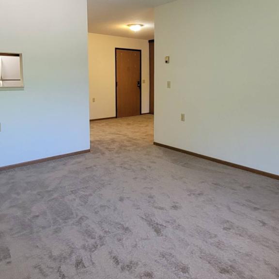 a room with a carpeted floor and a door.
