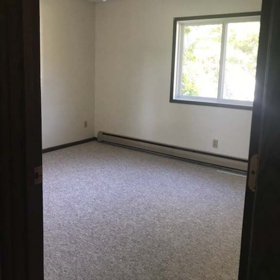 a room with a ceiling fan and a window.