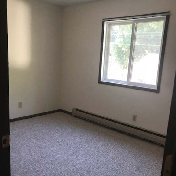 a room with a window and carpeted floor.