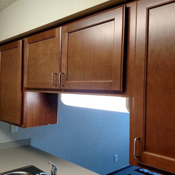 brown cabinets above a blue wall.