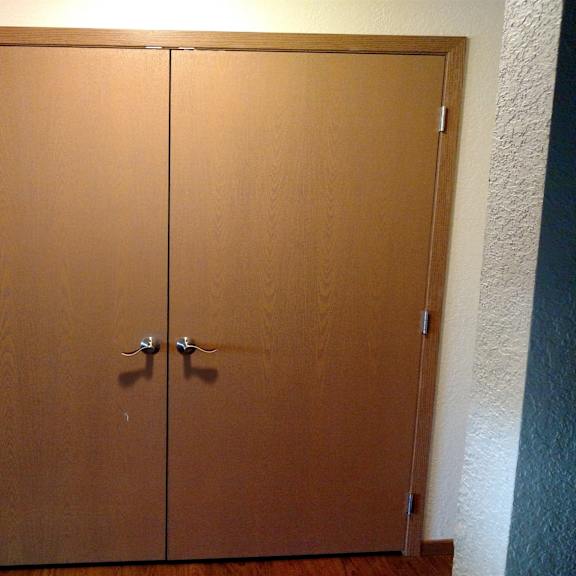 a brown double door with a silver handle.
