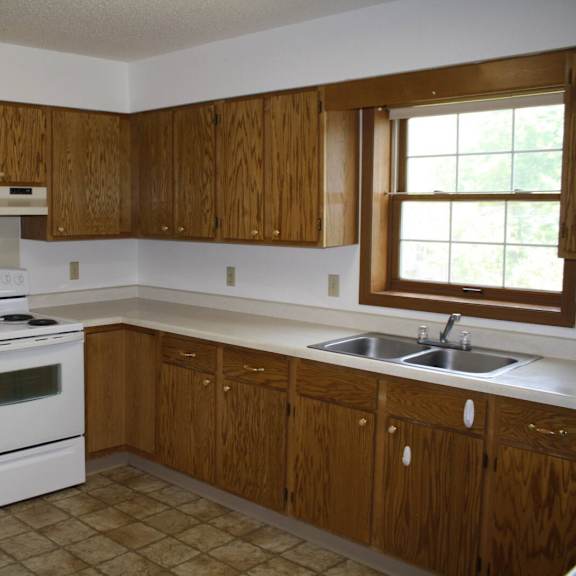 a kitchen with white appliances and wooden cabinets.