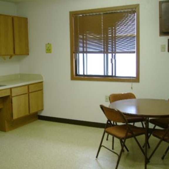 a kitchen with wooden cabinets and a table with chairs.