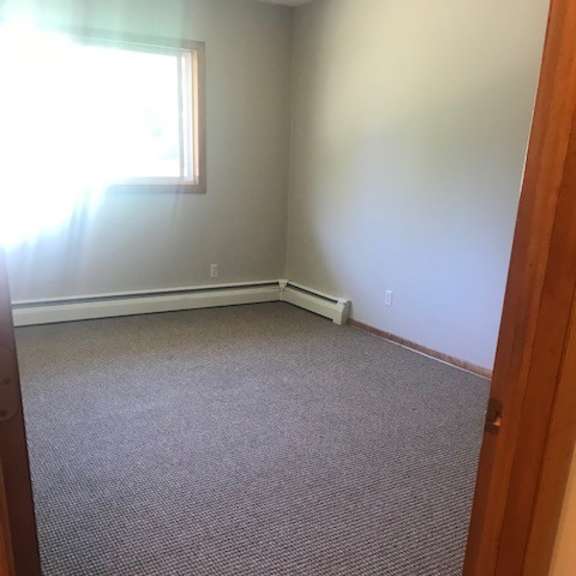 a room with a carpeted floor and a window.