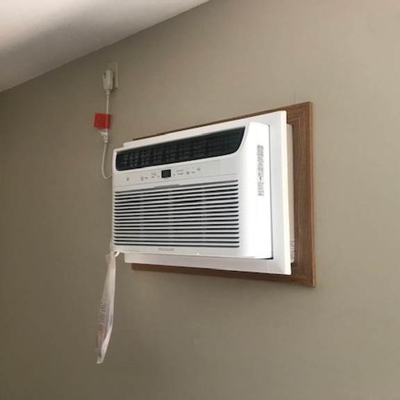 a white air conditioner is mounted on a wall.
