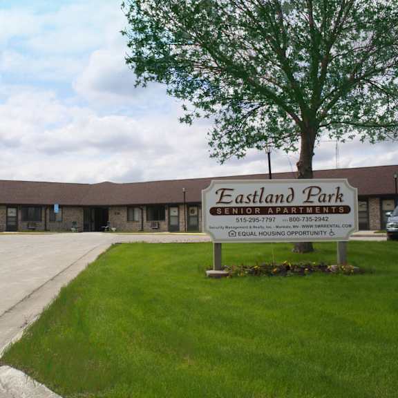 a sign for eastland park coal housing opportunity stands in front of a building.