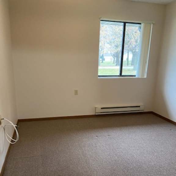 a room with a window and a carpeted floor.