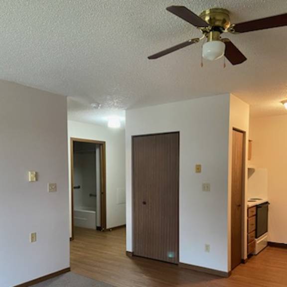 a room with a ceiling fan and a door.