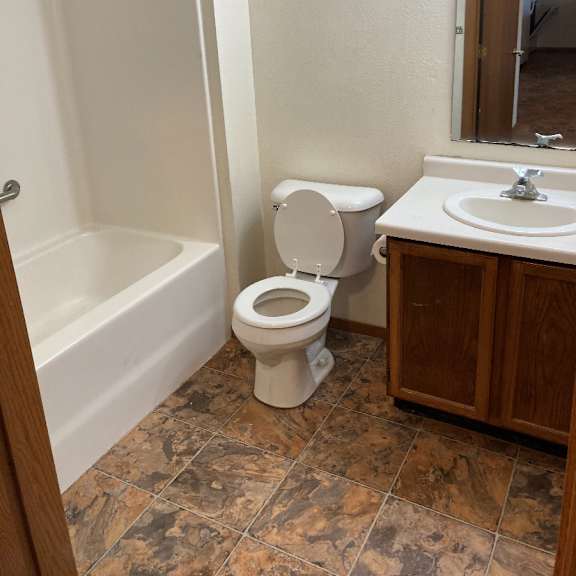 a white toilet sits in a bathroom next to a bathtub and sink.