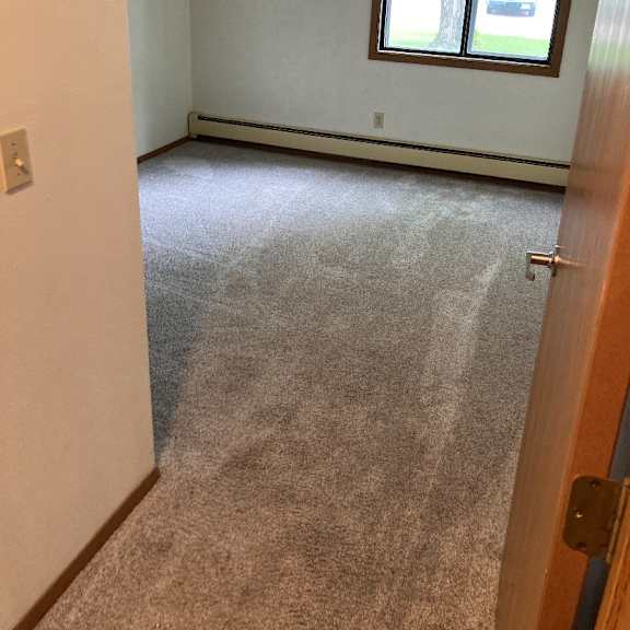 a room with a carpeted floor and a window.