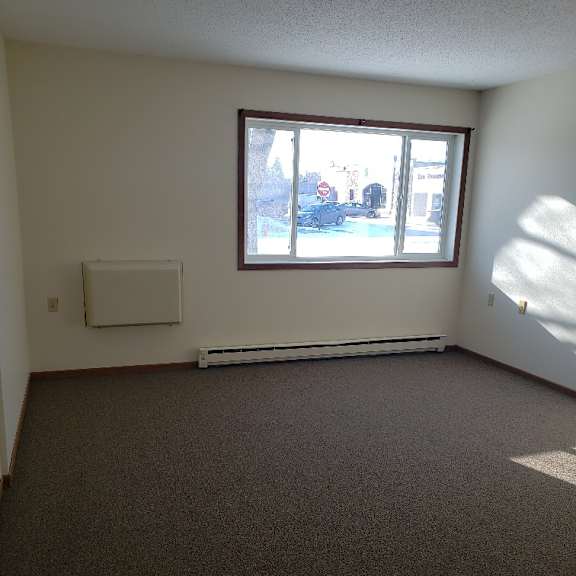 a room with a window and a white air conditioner unit on the wall.