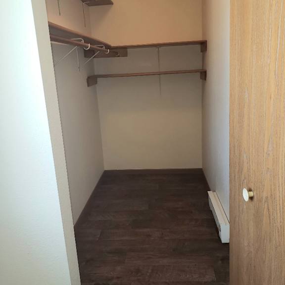 a room with a brown floor and a wooden door.