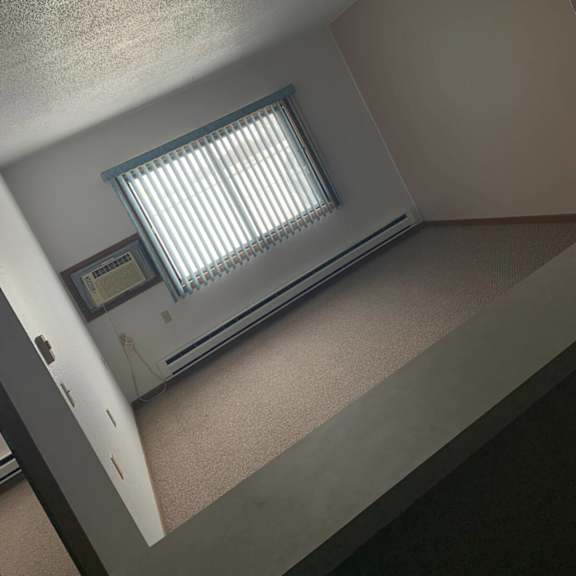 a small room with a window and a vent on the ceiling.