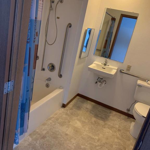 a bathroom with a sink, toilet, and shower.
