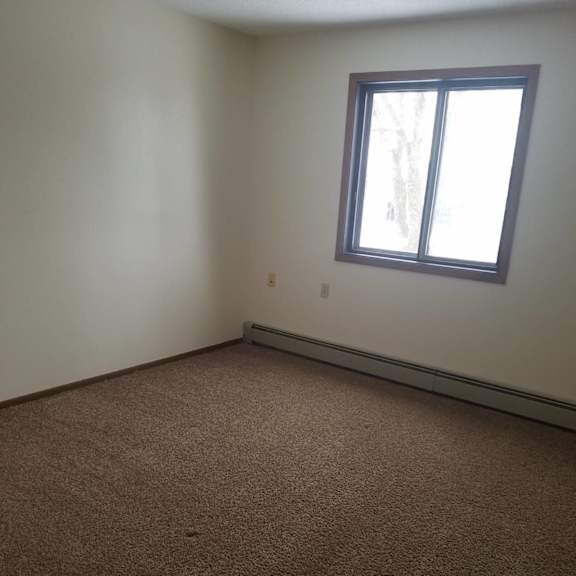 a room with a carpeted floor and a window.