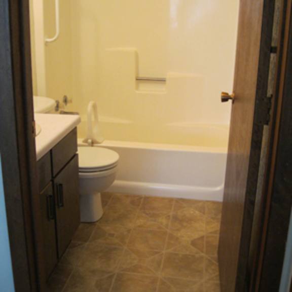 a white toilet sits next to a bathtub in a bathroom.