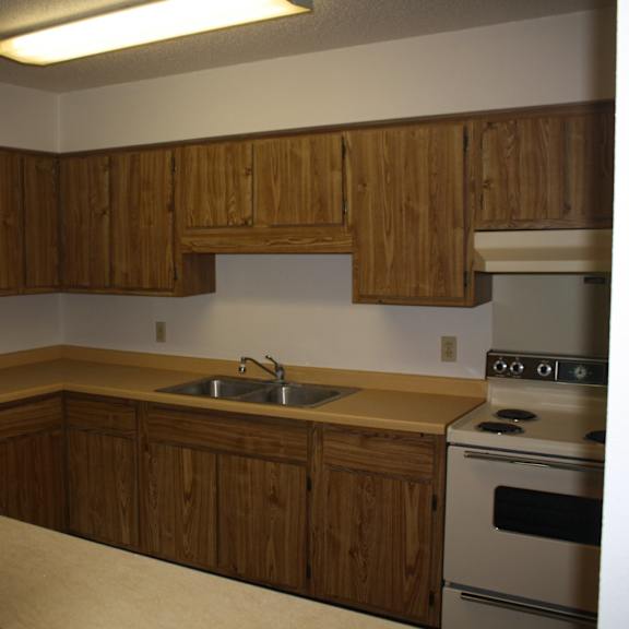 a kitchen with wooden cabinets and a stove.