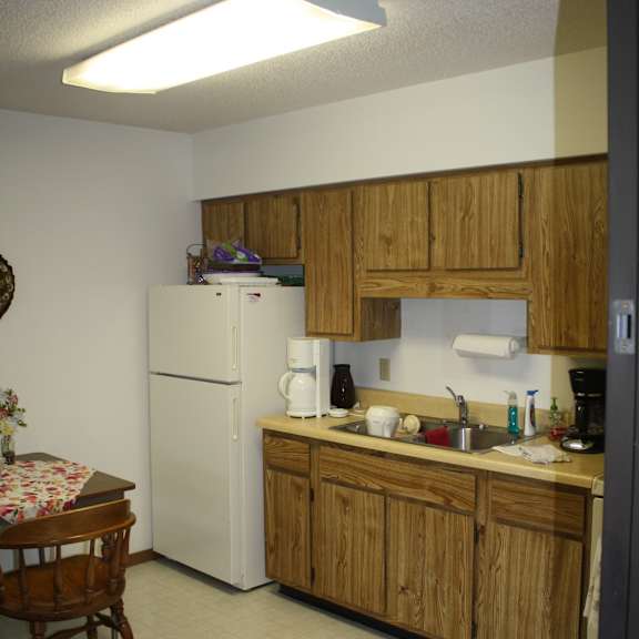 a kitchen with wooden cabinets and a white refrigerator.