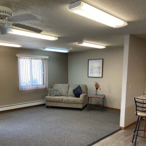 a room with a couch, a chair, and a table with flowers on it.