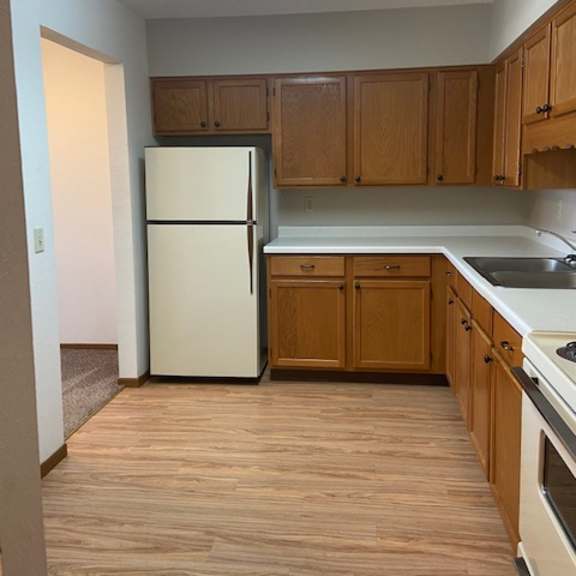 a kitchen with wooden cabinets and a white refrigerator.