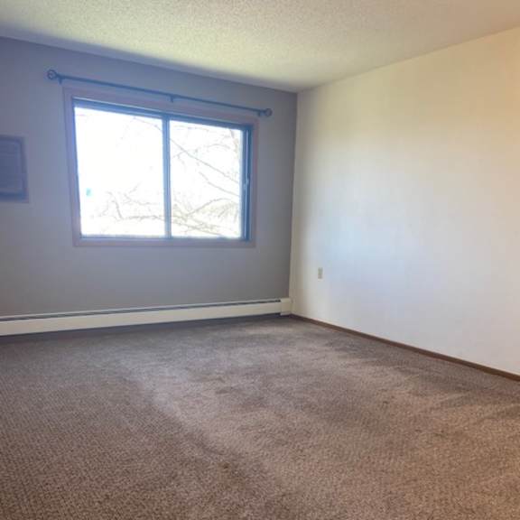 a room with a carpeted floor and a window.