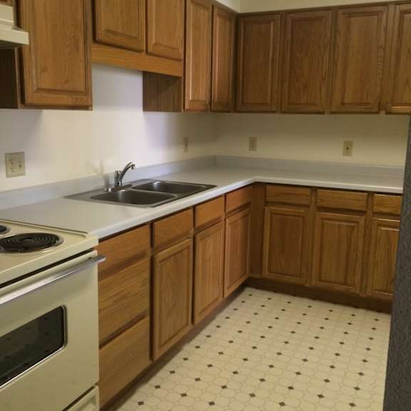 a kitchen with wooden cabinets and a tiled floor.