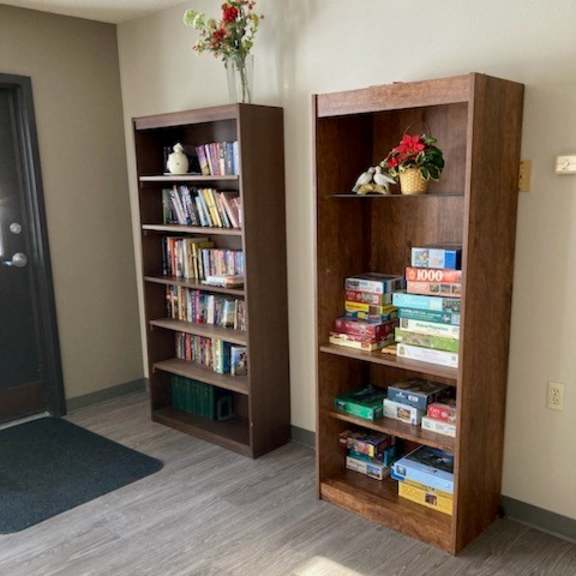 a room with two wooden bookshelves filled with books and some decorative items.