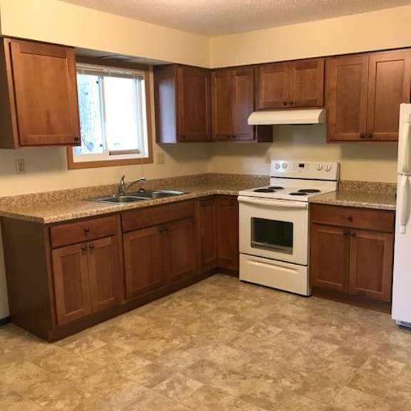 a kitchen with brown cabinets and a white refrigerator.