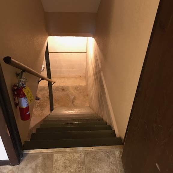 a staircase with a fire extinguisher on the wall.