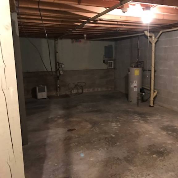 a basement with a concrete floor and a concrete wall.