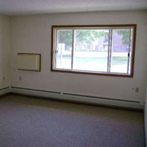 a room with a window and a picture frame on the wall.