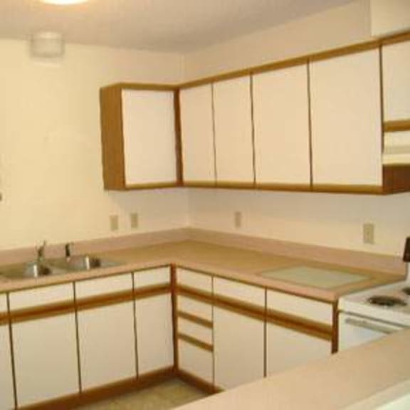 a kitchen with white cabinets and a white refrigerator.