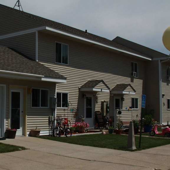 a house with a grey and white exterior and a brown roof.