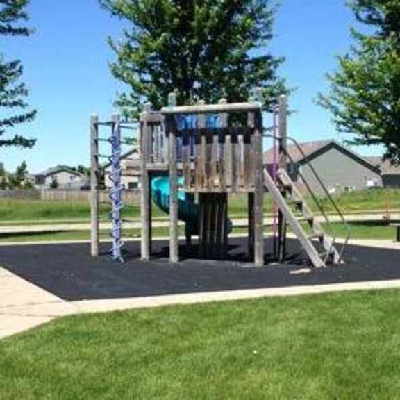 a playground with a slide and a wooden structure.