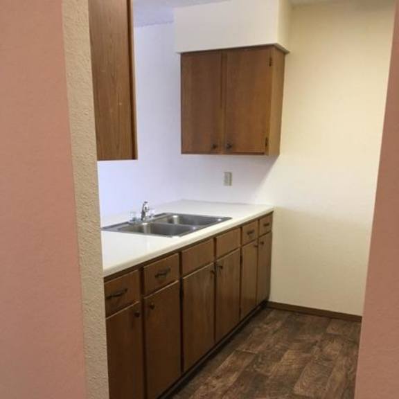 a kitchen with brown cabinets and a white sink.