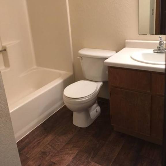 a white toilet sits next to a white sink in a small bathroom.