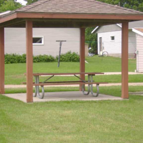 a wooden pavilion with a bench is in the foreground.