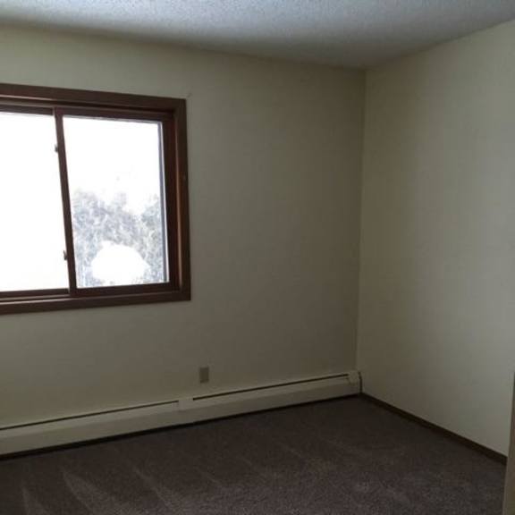 a room with a window and carpeted floor.