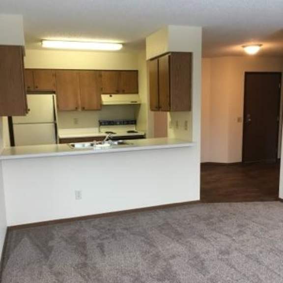 a kitchen with white countertops and wooden cabinets.