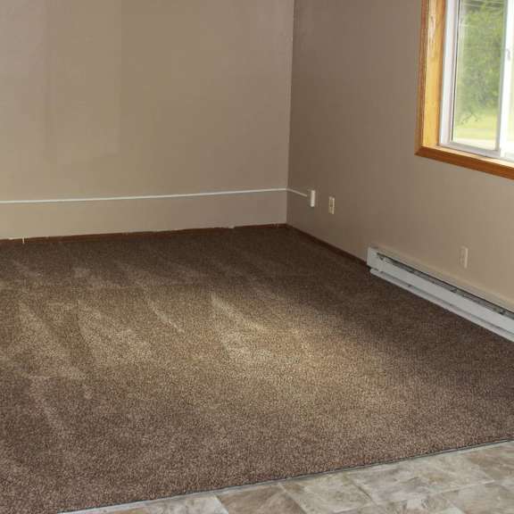 a room with a carpeted floor and a window.