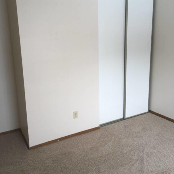 a room with a white wall and a carpeted floor.