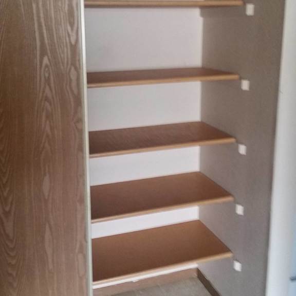a set of shelves in a room with a grey floor.