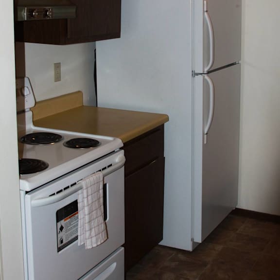 a white refrigerator stands in a kitchen next to a stove.