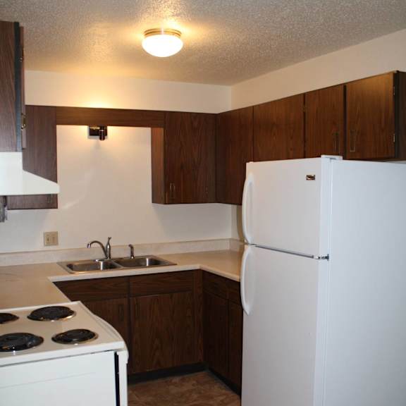 a kitchen with a white refrigerator and a white stove.