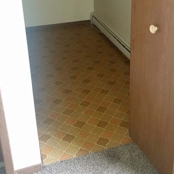 a room with a tiled floor and a wooden door.