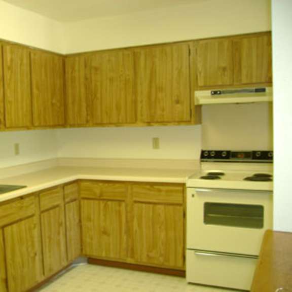 a kitchen with wooden cabinets and a white stove.