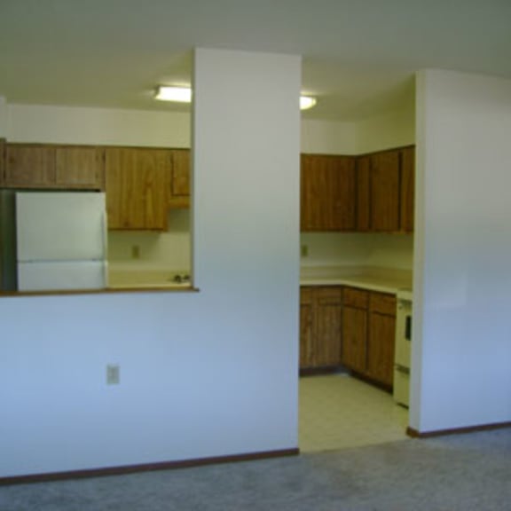 a kitchen with white appliances and wooden cabinets.
