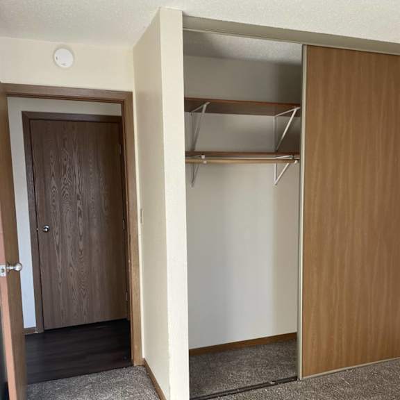 a room with a brown door and a white wall.
