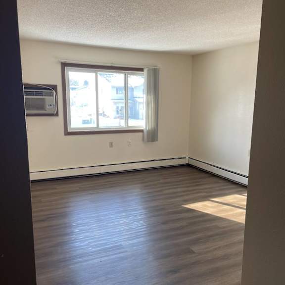 a room with a window and wooden flooring.